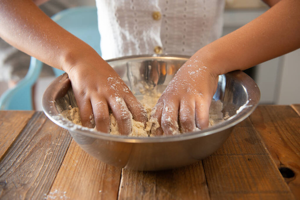 African American girl in her home kitchen making a pastry dough - Foto, imagen