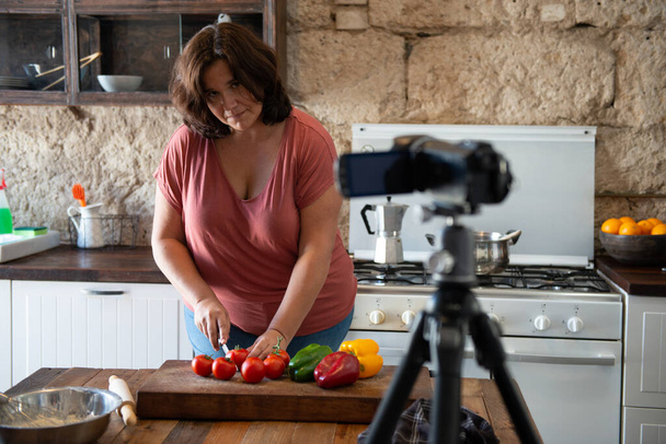 european woman creating content in her home kitchen for her social media channel - Foto, afbeelding
