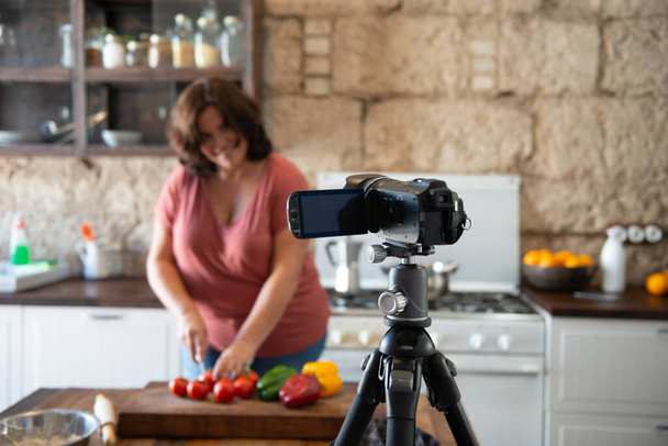 european woman creating content in her home kitchen for her social media channel - Zdjęcie, obraz