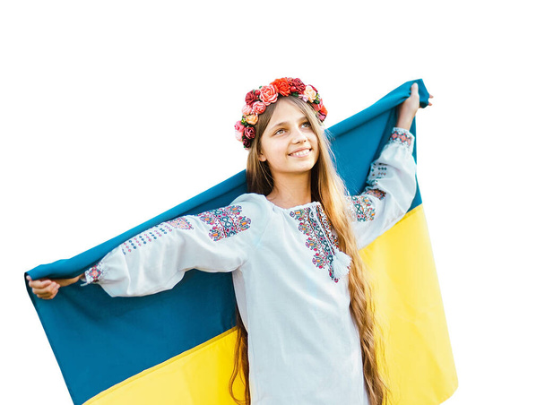 Ukrainian child girl in embroidered shirt vyshyvanka with yellow and blue flag of Ukraine in field. - Foto, immagini