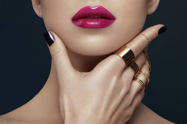 Cropped image of woman, with big lips, posing with hand on chin, over gray background, make up lips and nail concept. - Zdjęcie, obraz