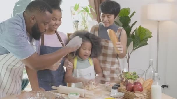 Famiglia afroamericana indossa grembiule trebbia farina per cucinare e ballare e cantare insieme in cucina a casa, genitore e bambino preparare cibo e canto con divertimento e giocoso. - Filmati, video