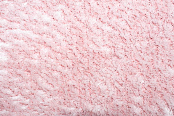 ピンクのファーのテクスチャトップビュー。抽象的な壁紙、テキスタイル表面。コーラルふわふわ生地のコートの背景。冬のファッションカラートレンド女性のフラットレイ、テキストのデザインのための女性のブログの背景.  - 写真・画像