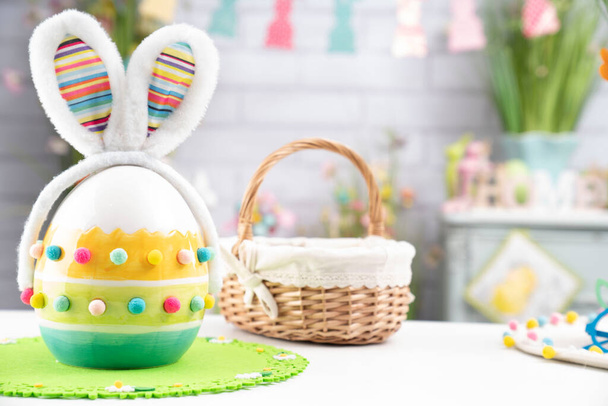 Easter time. Easter decorations on the white background. Easter bunny, easter eggs in basket. Bouquets of spring flowers.  - Фото, изображение
