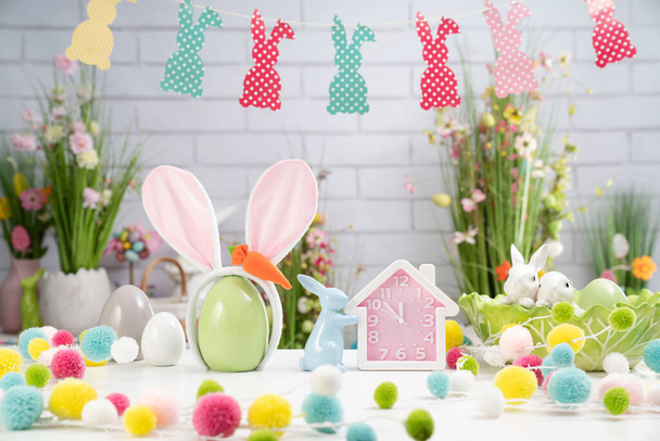 Easter time. Easter decorations on the white background. Easter bunny, easter eggs in basket. Bouquets of spring flowers.  - Zdjęcie, obraz