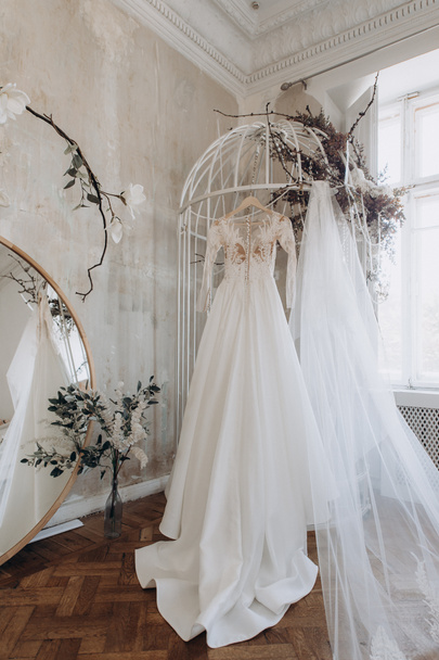 vestido de novia colgando en la puerta del armario - Foto, Imagen
