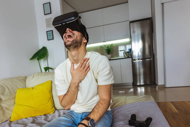 Férfi visel virtuális valóság szemüveg a nappaliban. - Fotó, kép