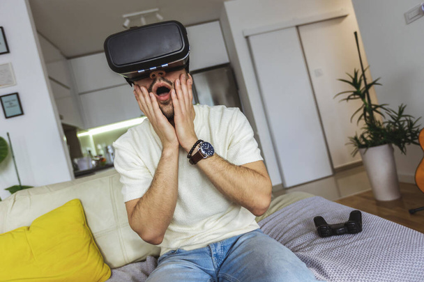Man met virtual reality bril in de woonkamer. - Foto, afbeelding