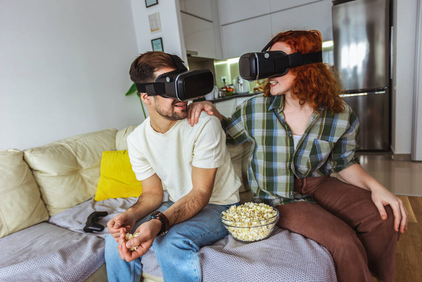 Virtual journey. Couple in casual clothes wear the virtual reality glasses are watching and showing imagine via the VR camera - Photo, Image