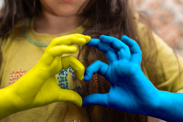 Понятие любви к Украине. руки в форме сердца окрашены в цвет флага Украины - желтый и синий. День независимости Украины, Флаг, День Конституции Концепция образования, школы, живописи - Фото, изображение