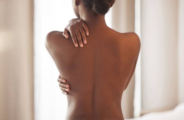 Я прикрою свою спину, когда дело доходит до заботы о моем теле. Снимок сзади молодой женщины, позирующей без тонировки. - Фото, изображение