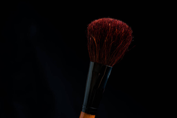 make-up brush with powder of different colors on a dark background like space dust - Zdjęcie, obraz