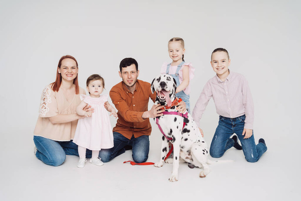 Famille jouer avec un chien dalmate sur fond blanc - Photo, image