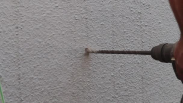 Perforación de un agujero en una pared de hormigón utilizando una máquina de perforación de energía eléctrica de servicio pesado - Metraje, vídeo