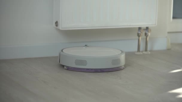 Witte robot stofzuiger apparaat reinigen vloer van kruimels thuis - Video