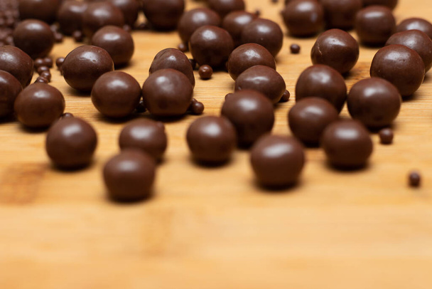 různé druhy čokoládových kuliček na dřevěném stole - Fotografie, Obrázek
