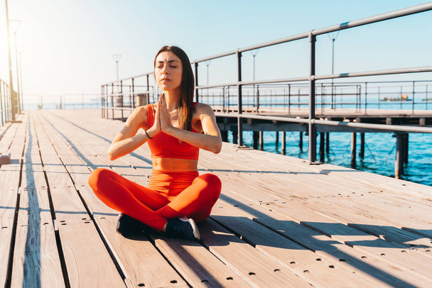 Mulher relaxante na posição de ioga no verão em frente ao mar - Foto, Imagem