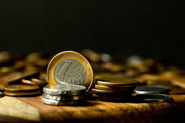 copia di una moneta reale brasiliana circondata da monete con sfondo nero - Foto, immagini