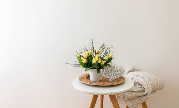 Composizione domestica con fiori in un vaso all'interno di una stanza bianca. - Foto, immagini
