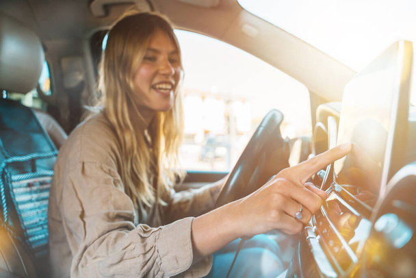 Vrouw selecteert de bestemming met auto gps navigator - Foto, afbeelding