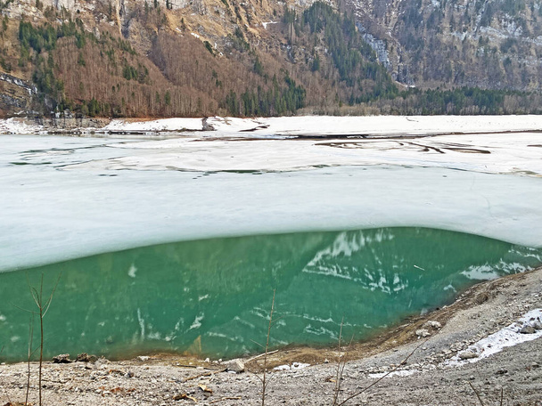 Sciogliere un lago ghiacciato Klontalersee o Klontaler Lake all'inizio della primavera nella valle alpina Klontal (o Kloental) e nel massiccio delle Alpi Glarus - Cantone di Glarus, Svizzera / Schweiz - Foto, immagini