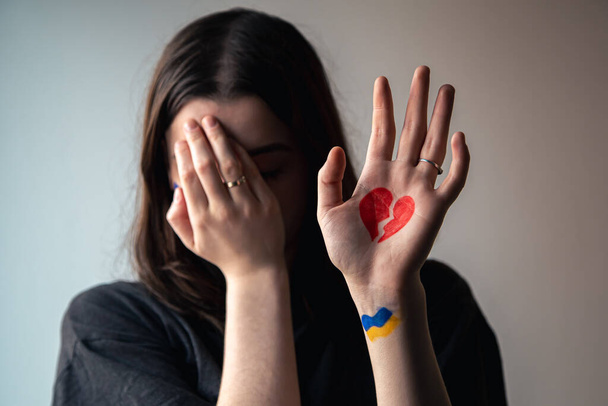 Ukrajinská dívka se zlomeným srdcem na ruce, bolest pro Ukrajinu. - Fotografie, Obrázek