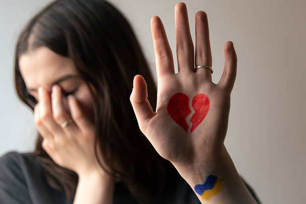 Ukraińska dziewczyna ze złamanym sercem na dłoni, ból dla Ukrainy. - Zdjęcie, obraz