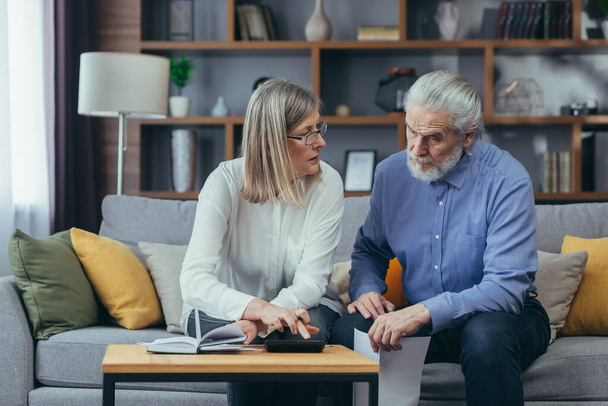 gray hair mature senior couple counting money and calculating finances while preparing tax report at home Older family with payment domestic bill checking financial documents, planning budget together - Foto, Imagem