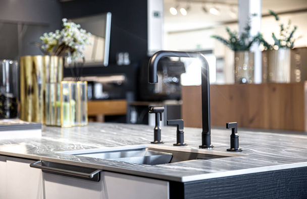 Fekete csaptelep acél mosogatóval egy elegáns modern konyhában. - Fotó, kép