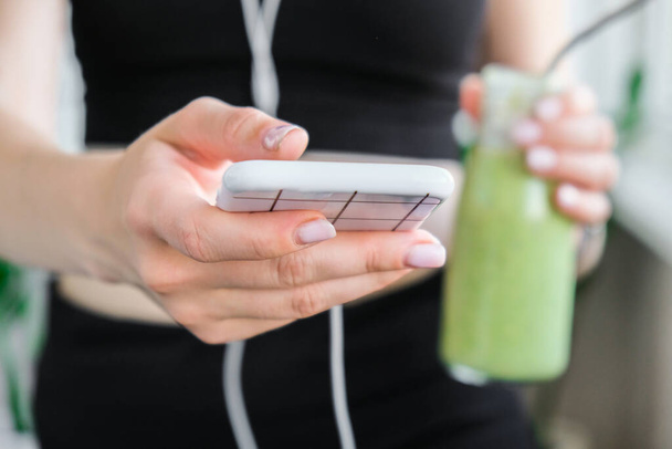 junge Millenials checken Smartphone trinken vegane Smoothie-Drink Detox. Frau macht Yoga-Übungen zu Hause. Online-Unterricht sauberes Essen, Gewichtsverlust, gesundes Ernährungskonzept. Gesund bleiben. wellness - Foto, Bild