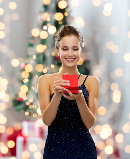 smiling woman holding red gift box - Фото, изображение