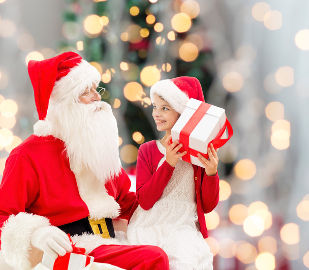 smiling little girl with santa claus and gifts - Foto, Bild