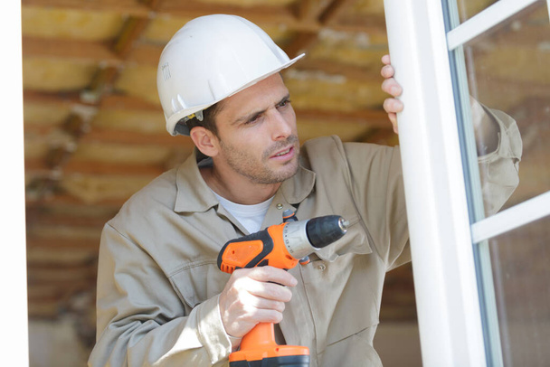 a man drilling window frame - Photo, Image