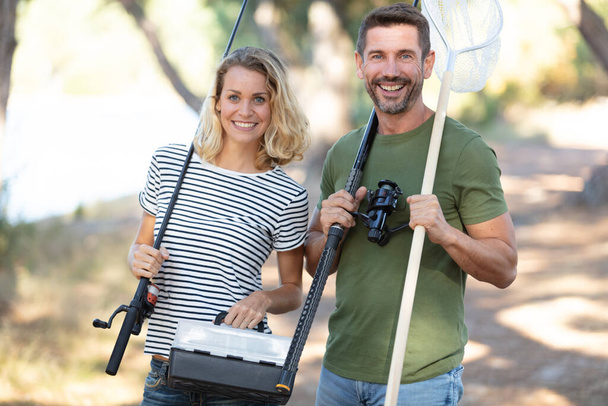 couple going fishing with fish rod and net - 写真・画像