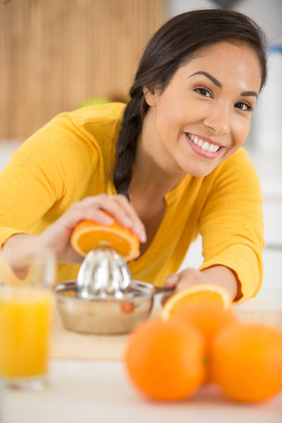 woman manually squeezing an orange - Photo, image