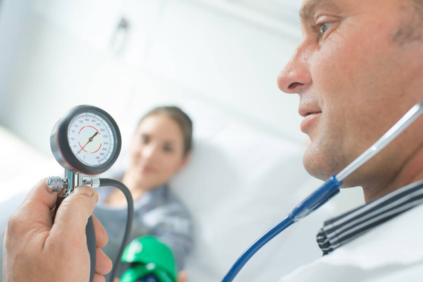 a doctor measuring blood pressure - Фото, зображення