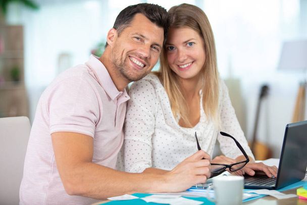 happy young couple with laptop at home - Foto, imagen