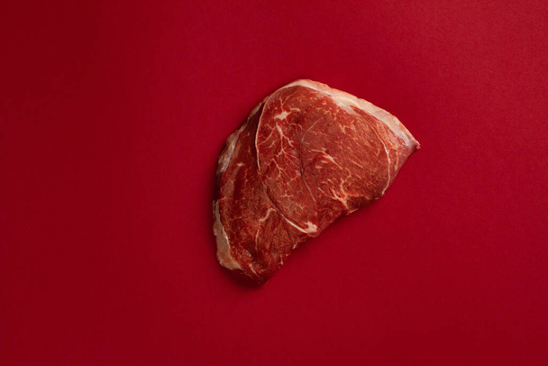 Raw beef meat steak isolated on a blood background - Photo, image