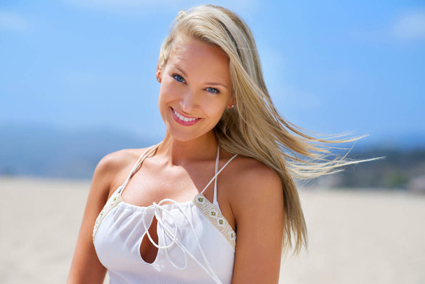彼女はビーチをさらに魅力的にします。ビーチで笑っている幸せな若い女性のショット. - 写真・画像