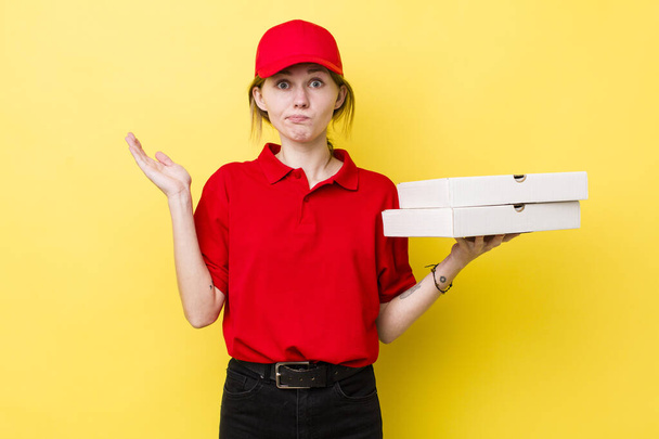 red head pretty woman feeling puzzled and confused and doubting. delivery pizza concept - Photo, image