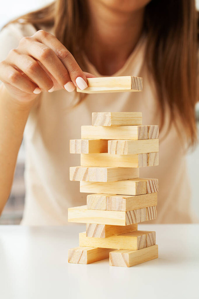 Mano de una joven mujer de negocios Para jugar a bloques de madera con la estrategia y la planificación de proyectos de negocios - Foto, imagen