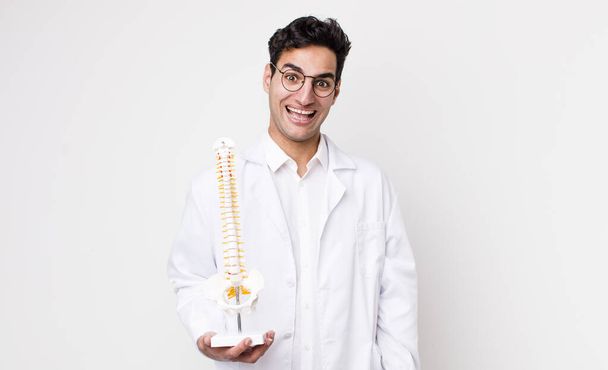 handsome hispanic man looking happy and pleasantly surprised. spine specialist concept - Φωτογραφία, εικόνα