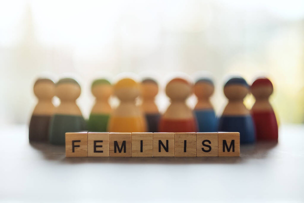 FEMINISM λέξη για ξύλινα μπλοκ με μια ομάδα γυναικών στο παρασκήνιο - Φωτογραφία, εικόνα