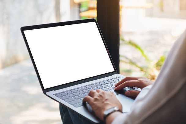 Immagine mockup di una donna che utilizza e digita sul computer portatile con schermo bianco vuoto  - Foto, immagini