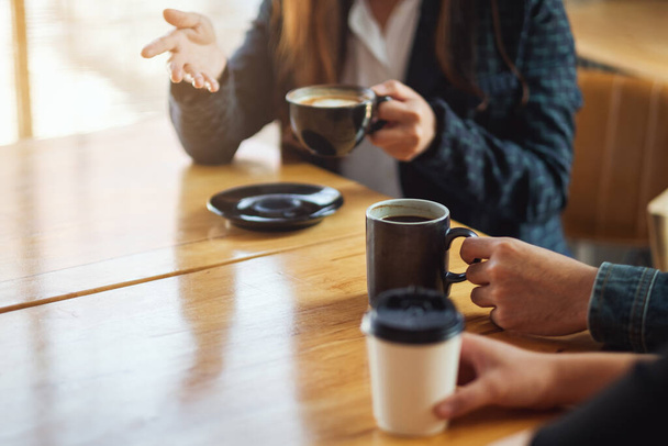 Κοντινό πλάνο εικόνα των ανθρώπων απολαμβάνουν μιλάμε και πίνοντας καφέ μαζί στο καφέ - Φωτογραφία, εικόνα