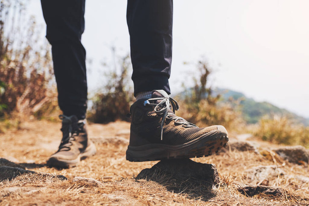 Dağın tepesinde yürüyüş botlarıyla bir kadının bacaklarının yakın görüntüsü. - Fotoğraf, Görsel