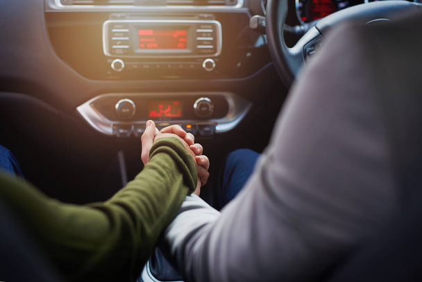 Das Leben ist eine Reise, die man am besten gemeinsam geht. Nahaufnahme eines Paares beim Händchenhalten während der Fahrt im Auto. - Foto, Bild