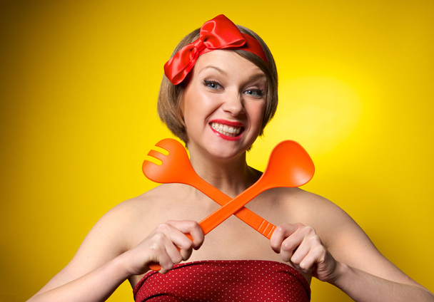 Pinup style housewife with kitchen utensils - 写真・画像