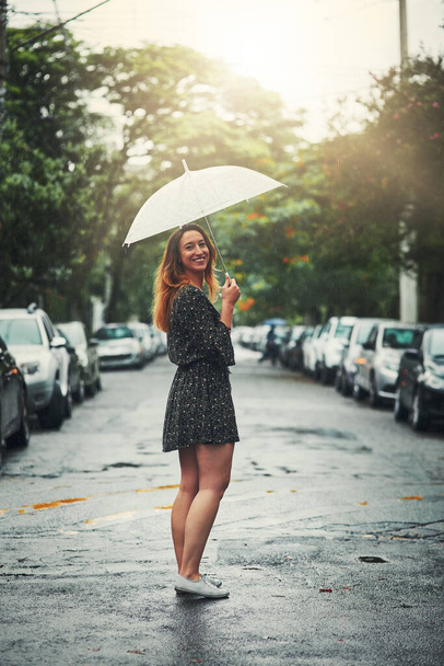 Akár esik, akár nem, szeret kint lenni. Egy gyönyörű fiatal nőről, aki kint sétál az esőben.. - Fotó, kép