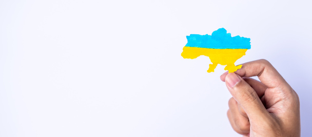 Support for Ukraine in the war with Russia, Hands holding the shape of Ukraine border with color flag. Pray, No war, stop war and stand with Ukraine - Photo, Image